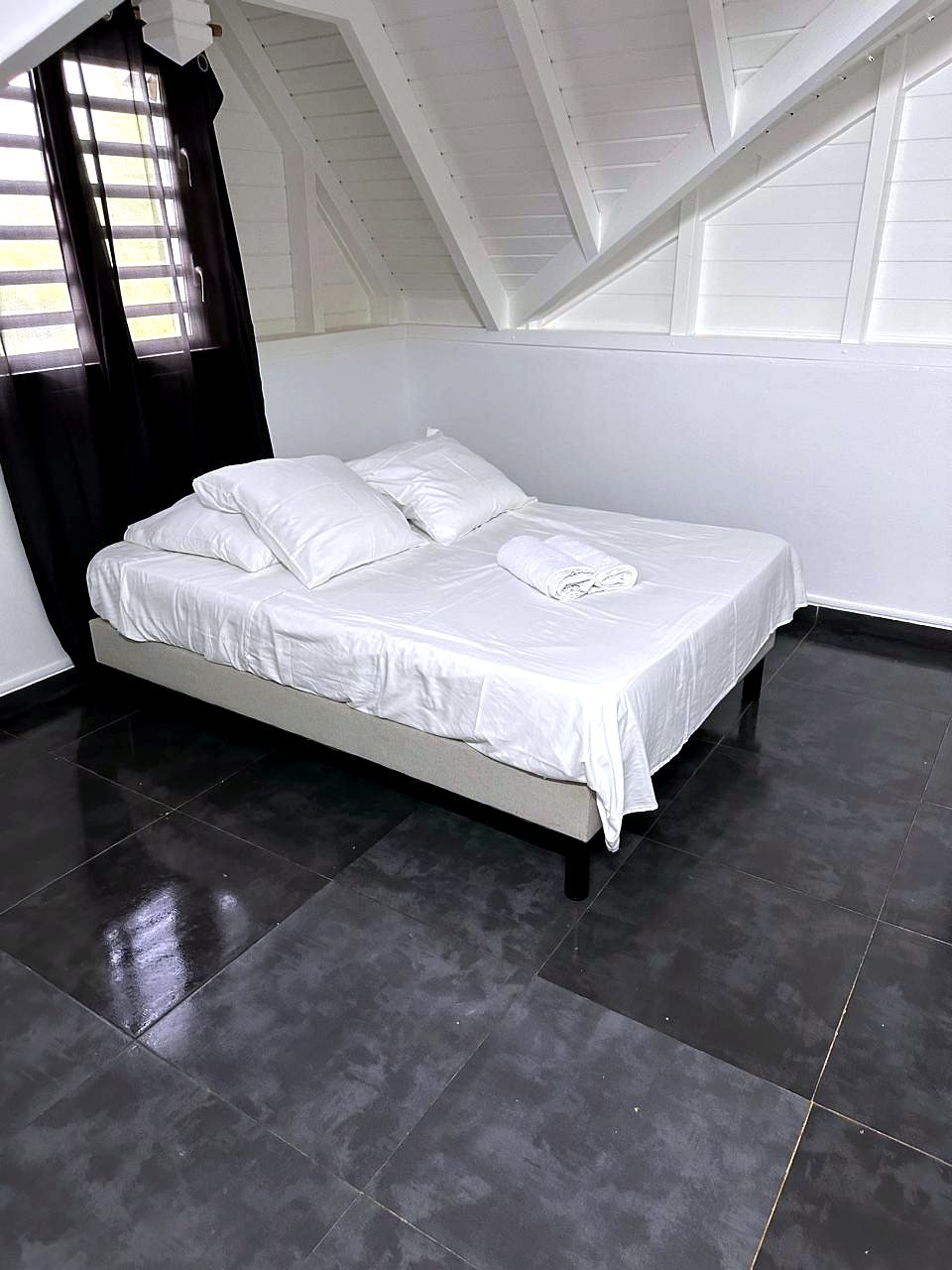 Chambre mansardée sous la charpente blanche