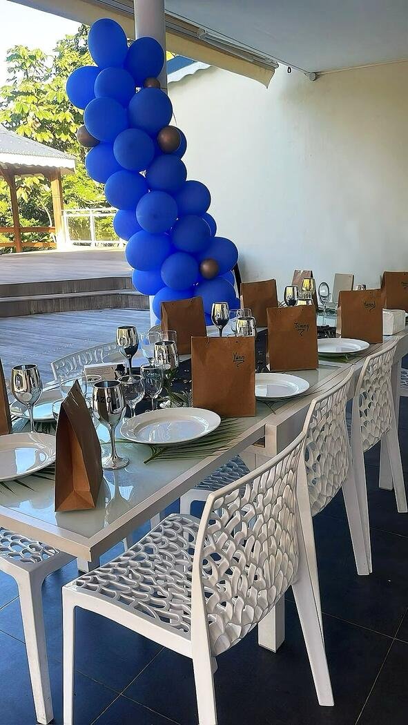 Table de baptême décorée d'une arche de ballons bleus