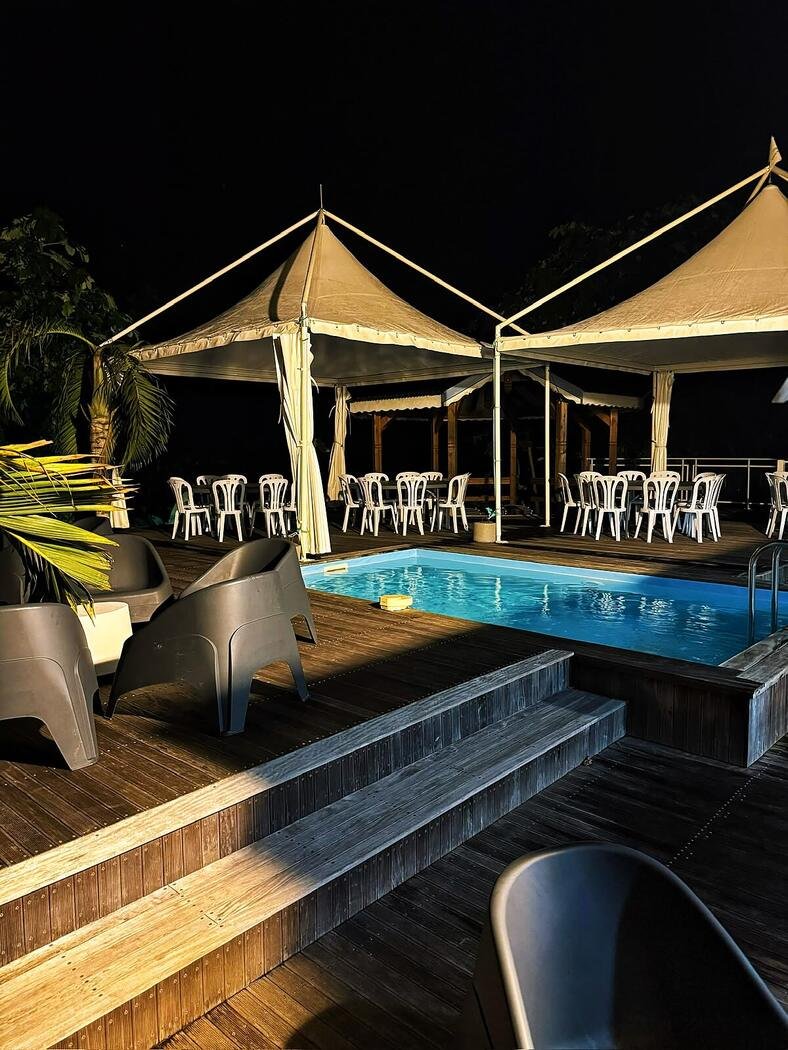 Réception de nuit sous les chapiteaux illuminés autour de la piscine